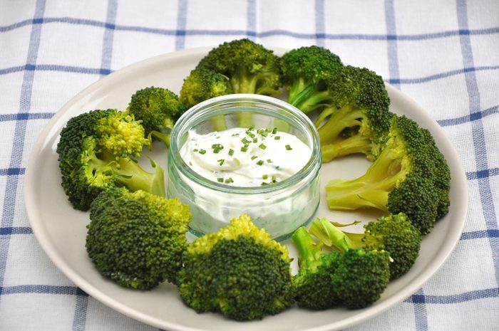A healthy snack of fresh broccoli and low fat dipping sauce