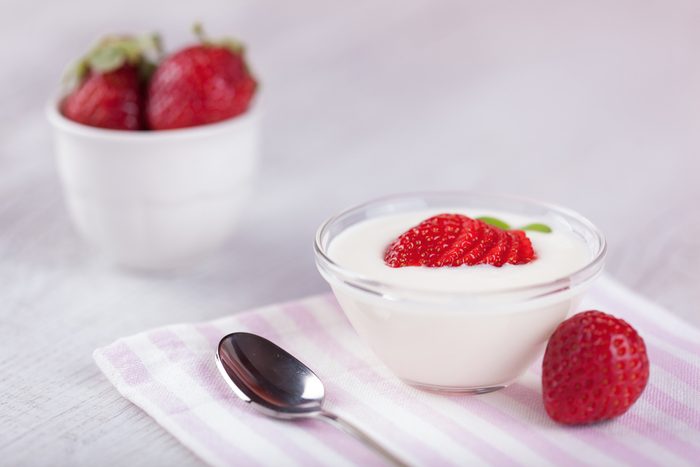 yogurt cream and strawberries on romantic background