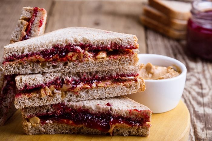 Peanut butter and jelly sandwich with whole wheat bread on rustic wooden table 