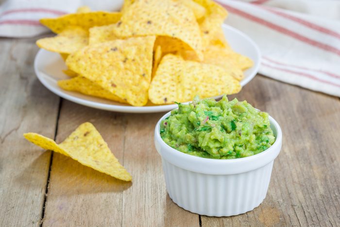 Cup with chunky guacamole served with nachos