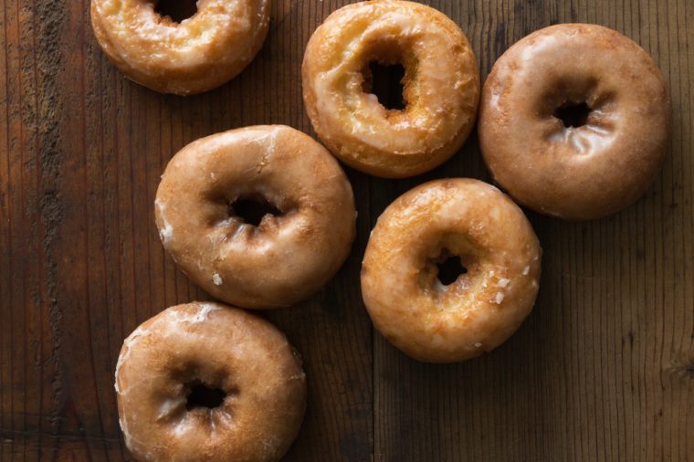 Top view of plain donuts on a wood background.