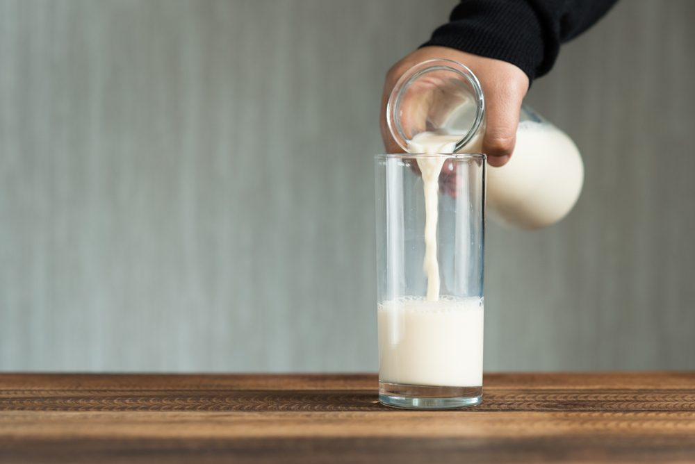 pouring milk into glass. filling a glass with milk.