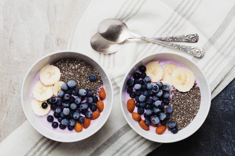 Yogurt with berries, banana, almonds and Chia seeds, bowl of healthy Breakfast every morning, vintage style, superfood and detox concept, top view