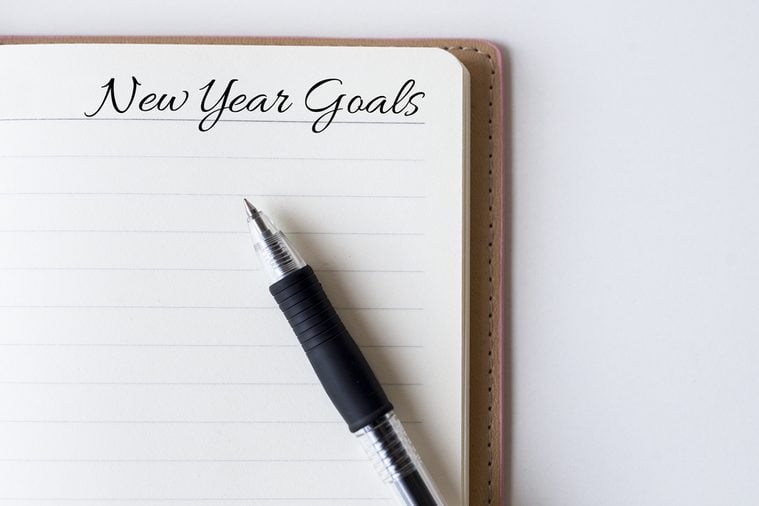 Conceptual,notebook on a white table. open diary and pen with new year goals words