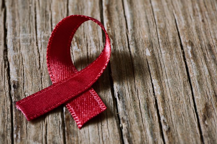 a red ribbon for the fight against AIDS on a rustic wooden surface