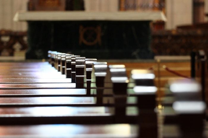 Rows of church benches. Sunlight reflection on polished wooden pews. Selective focus.