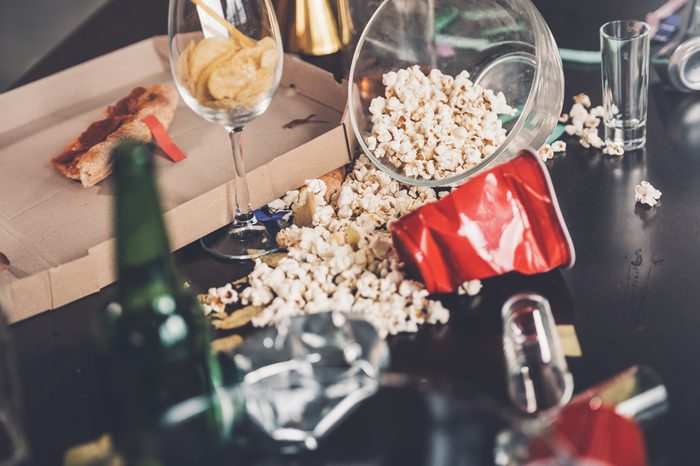 Close-up view of popcorn, glasses and trash on messy table after party 