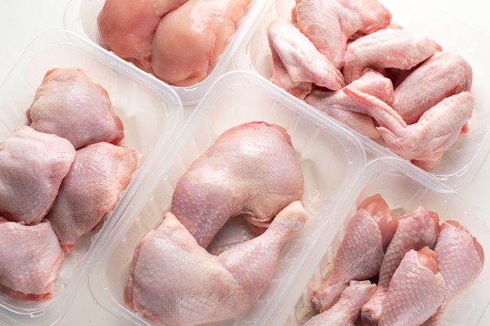 Different types of raw chicken meat in plastic boxes