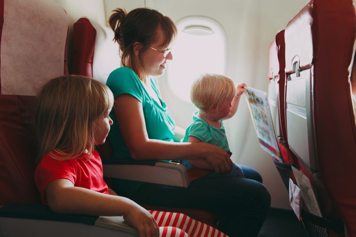 family travel by plane- mother wtih two kids in flight