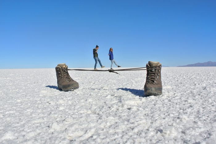 Optical Illusion Of Couple Walking On Shoelaces At Salt Flat