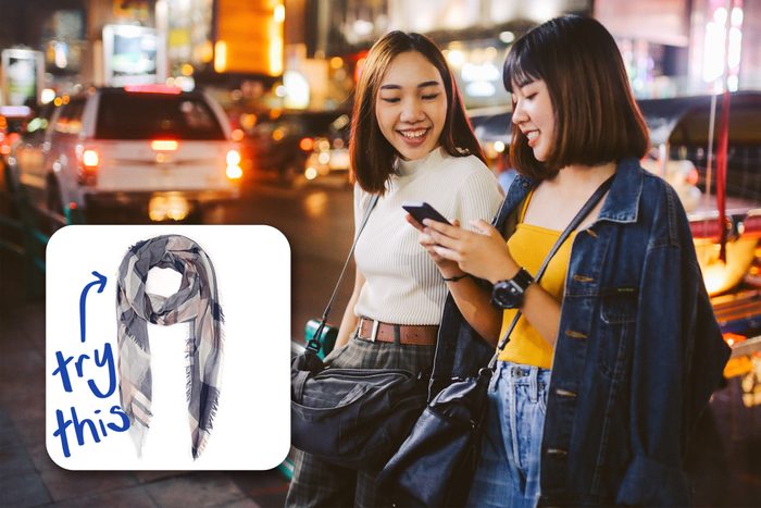 two trendy friends looking at a phone. try this scarf.