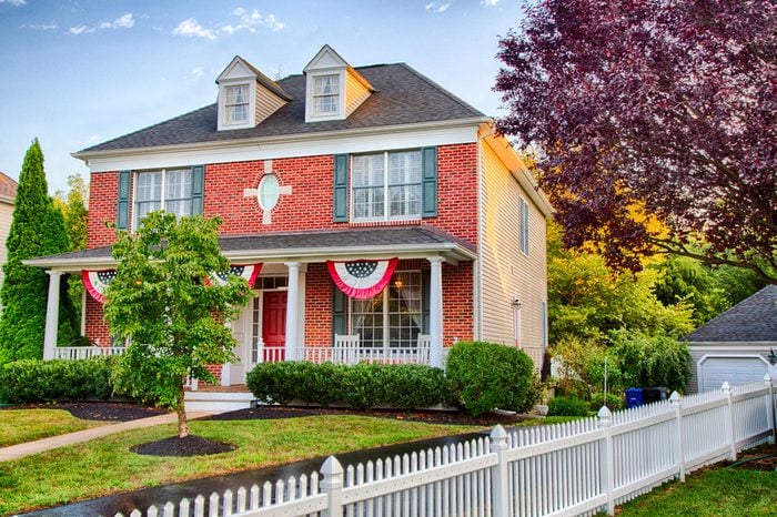 A colonial house in Medford, New Jersey with American Flag buntings on the porch.