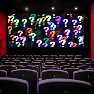 empty movie theatre with a screen of question marks