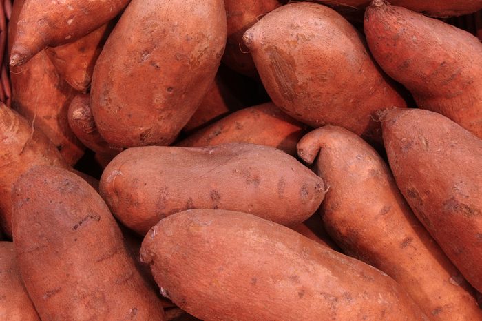 pile of sweet potatoes at a farmers market