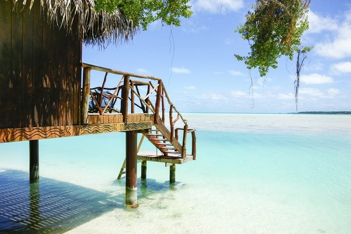 Tropical cabin over waters edge, Cook Islands, South Pacific.