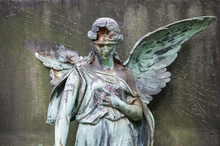 damaged sculpture of a female angel statue on cemetery