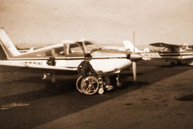 Pat Patterson in wheelchair next to plane