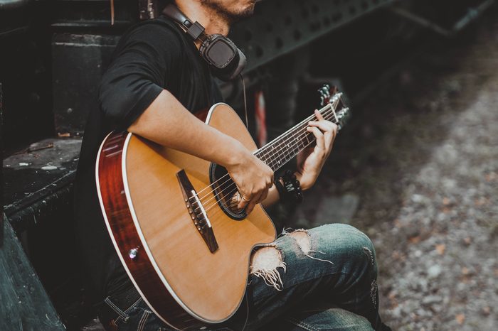 Handsome man musician playing the guitar