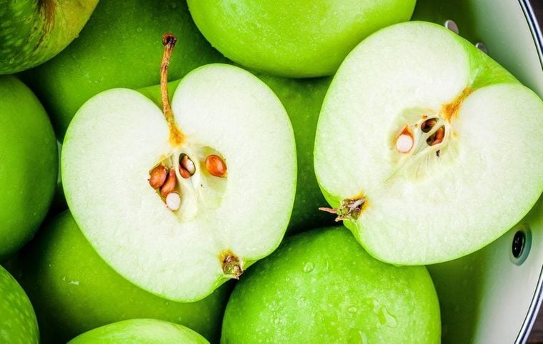 organic green juicy apples in colander closeup