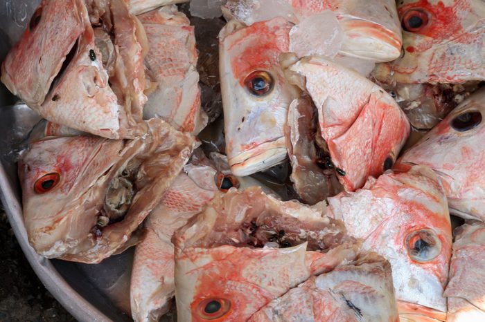 A bucket of colorful pink fish heads for sale at an Asian Market