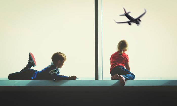 kids looking at plane in airport, family travel