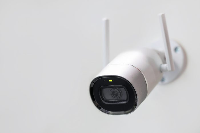 White surveillance camera. CCTV mounted on wall. Wifi wireless antennas enabled. Big brother watching you concept