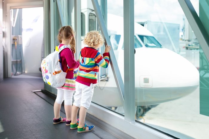 Kids at airport. Children look at airplane. Traveling and flying with child. Family at departure gate. Vacation and travel with young kid. Boy and girl before flight in terminal. Kids fly a plane