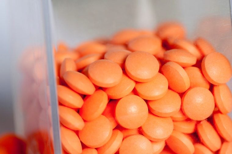 Orange pills in a glass containter, close-up.