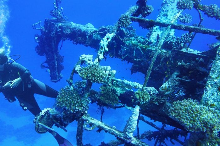 Woman scuba diver near shipwreck Salem Express, Red Sea Egypt