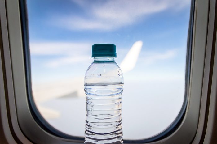 Bottle of water on clear sky from a plane. Travel concept.