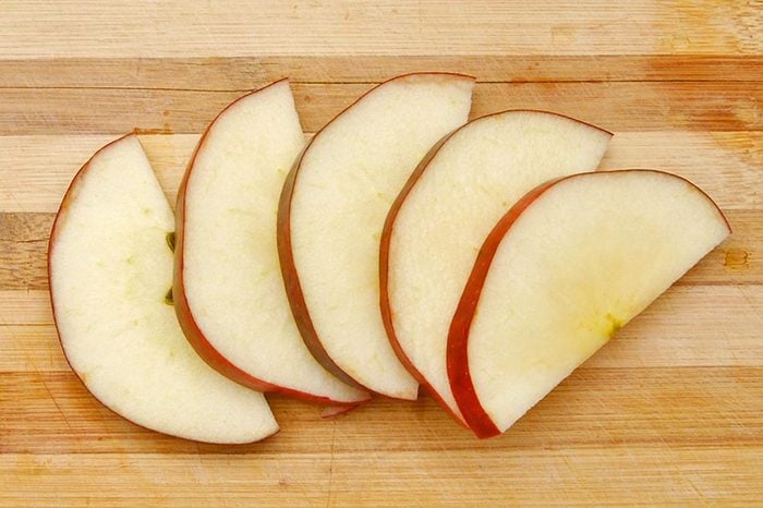 Sliced apple isolated on wooden board