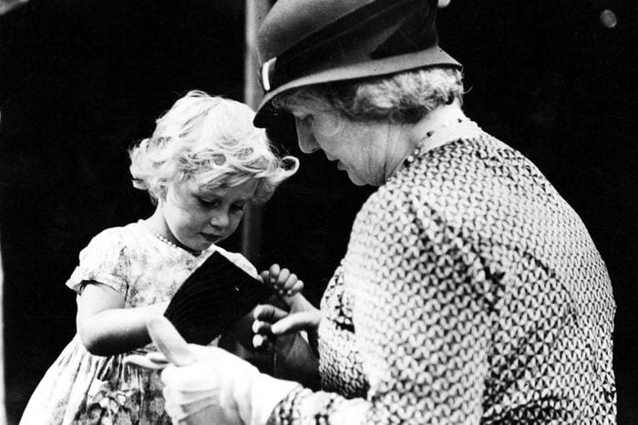 Various Princess Margaret selling white heather at garden fete