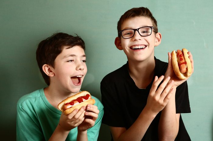 young boys eating hot dogs