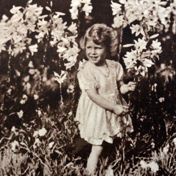 VARIOUS Princess Elizabeth later Queen Elizabeth II, as a child, gathering flowers in a garden, 1930.