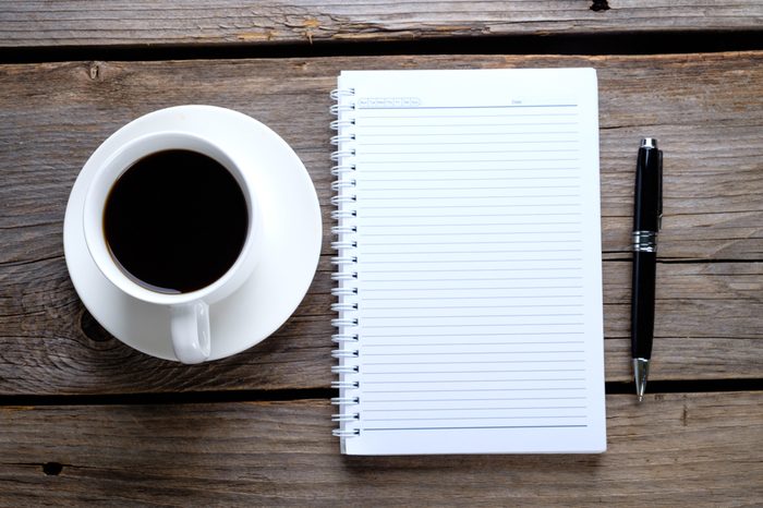 Blank notebook, coffee on rustic wooden background