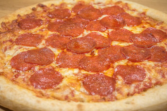 Pepperoni Pizza Up Close Studio Shot against a wooden background
