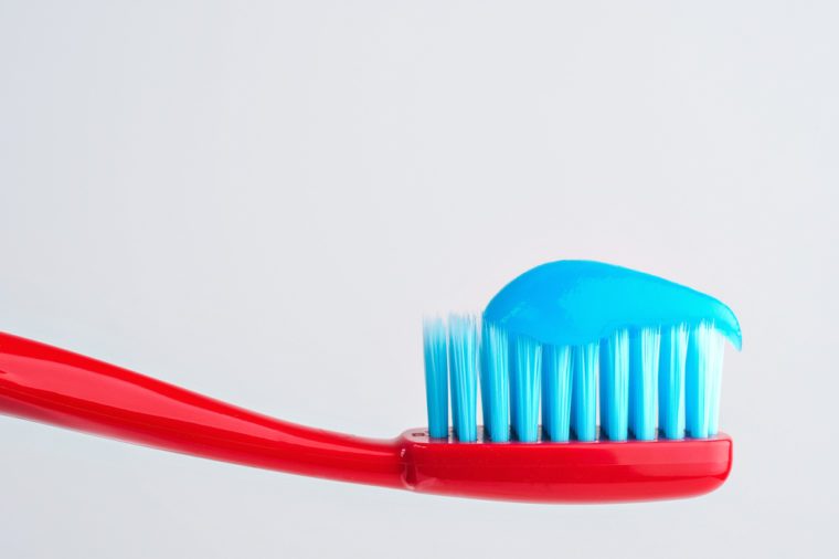Toothbrush with toothpaste on white background