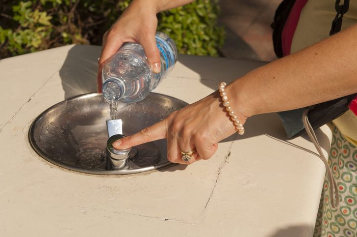 VARIOUS Model Released - People filling bottles with water from the drinking fountains at Disneyland Paris in France