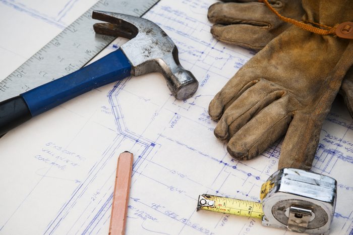 blue prints at a work site with tools and gloves