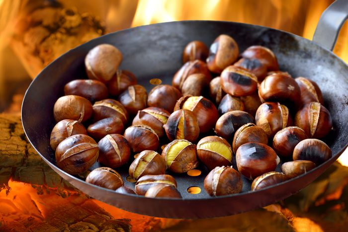 Roasting chestnuts in a special pan over an open fire