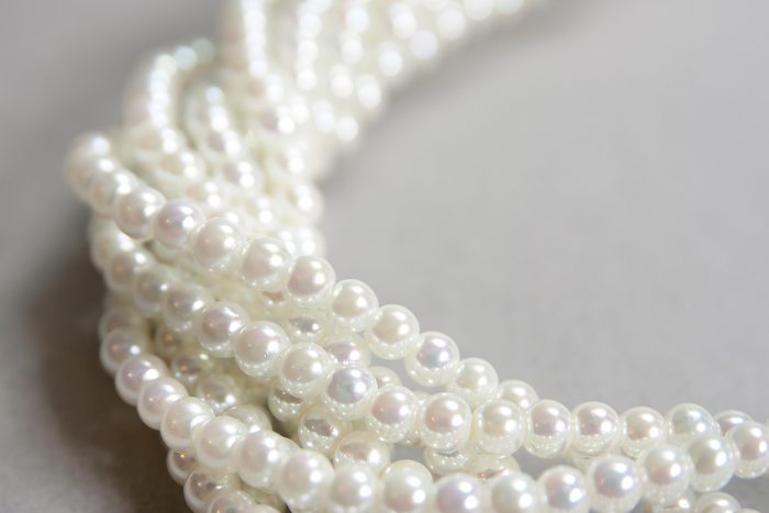 twisted strands of white pearls on a gray background