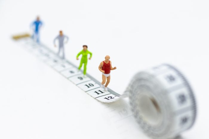 Miniature people running on waistline . Image use for healthy , exercise concept.