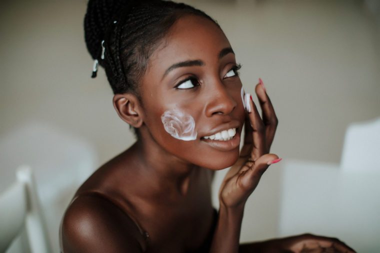 African American girl applying facial skincare product. Sexy woman face. Brutal sexy face girl. Hot babe. Erotic concept. Erotica. Passionate concept. Passion. Adult . Sensual. Sensuality
