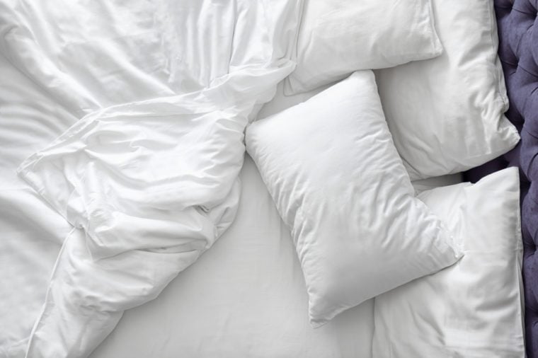 Comodo letto con lenzuola bianche a casa