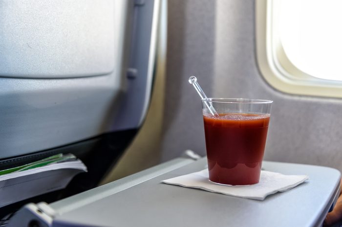 glas of tomato juice on a table in an airplane close to the airplane window
