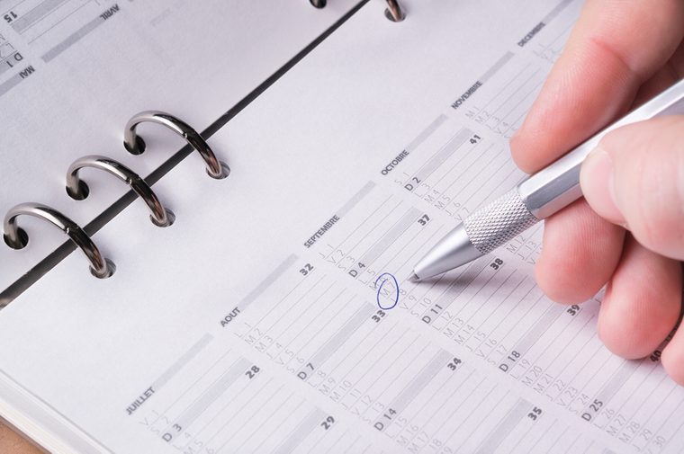 silver pen writing on open business agenda calendar