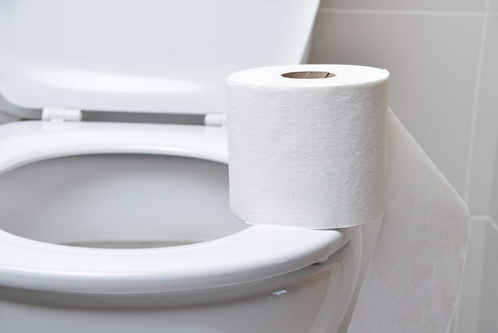 Toilet paper on a toilet with the lid open
