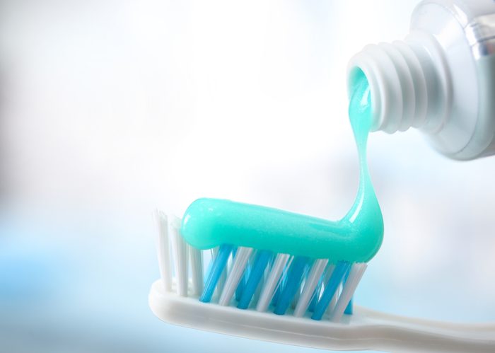 Toothbrush and toothpaste on blurred background