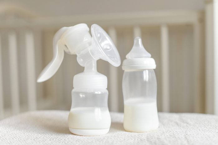 Manual breast pump and bottle with milk for baby