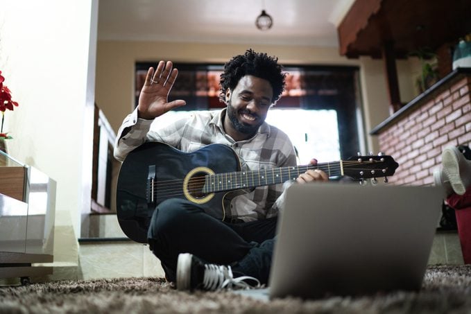 Acoustic Guitar Teaching Through A Video Call, Waving To Laptop At Home